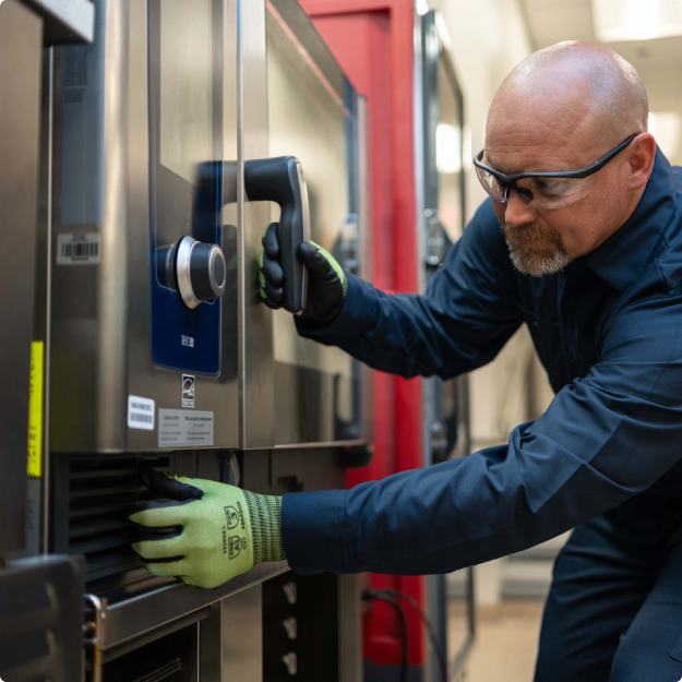Technician opening the door of a commercial combi oven