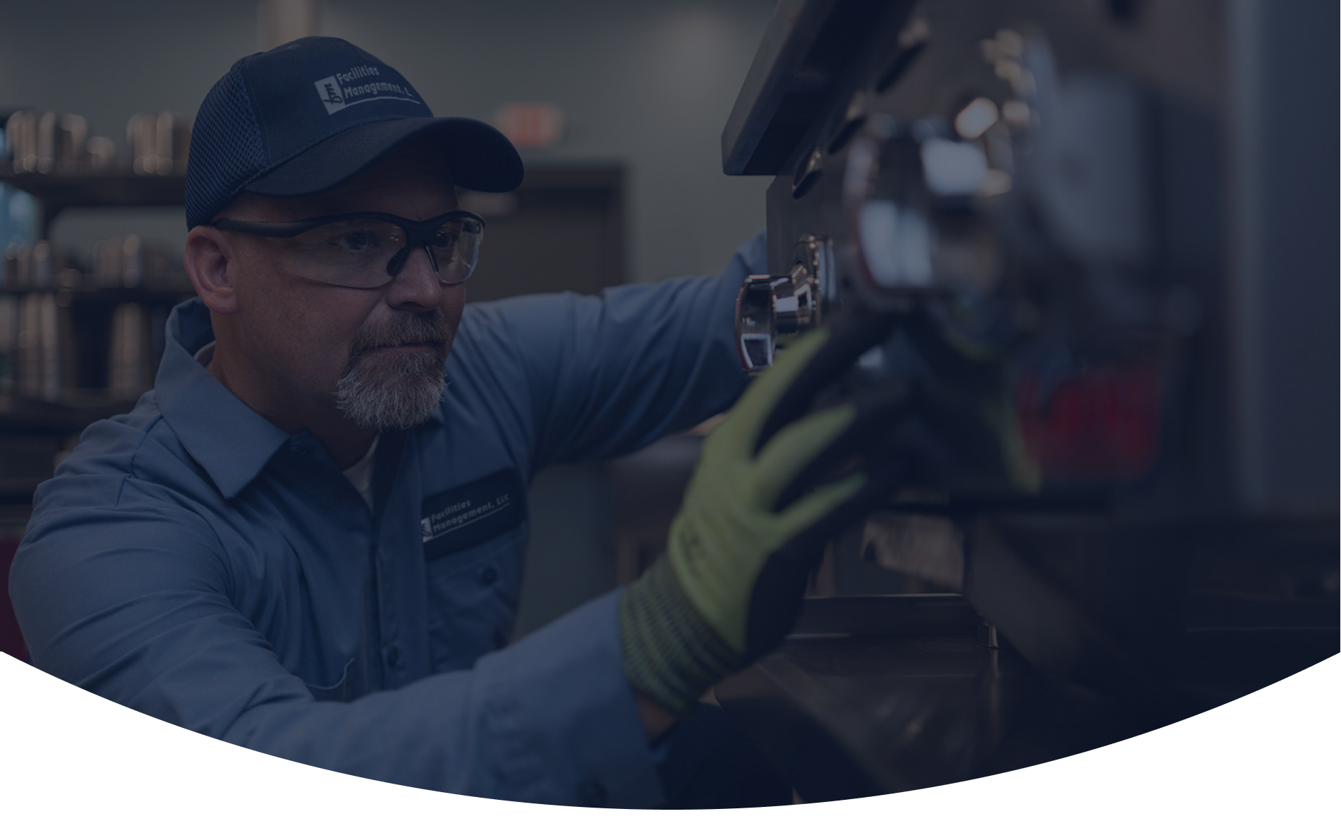 Facilities Management technician in a cap repairing commercial foodservice equipment