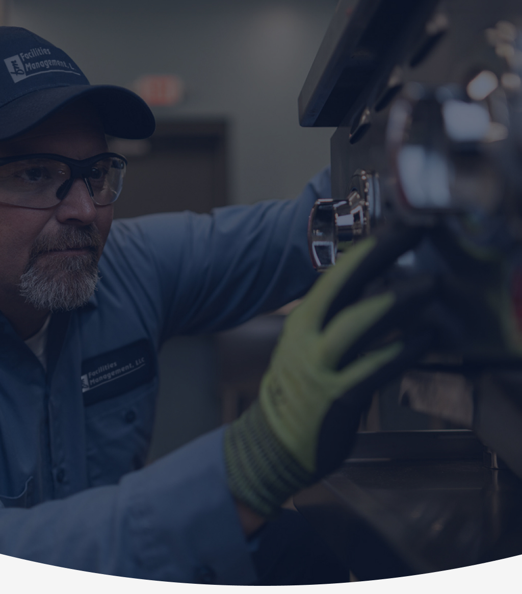 Facilities Management technician in a cap repairing commercial foodservice equipment